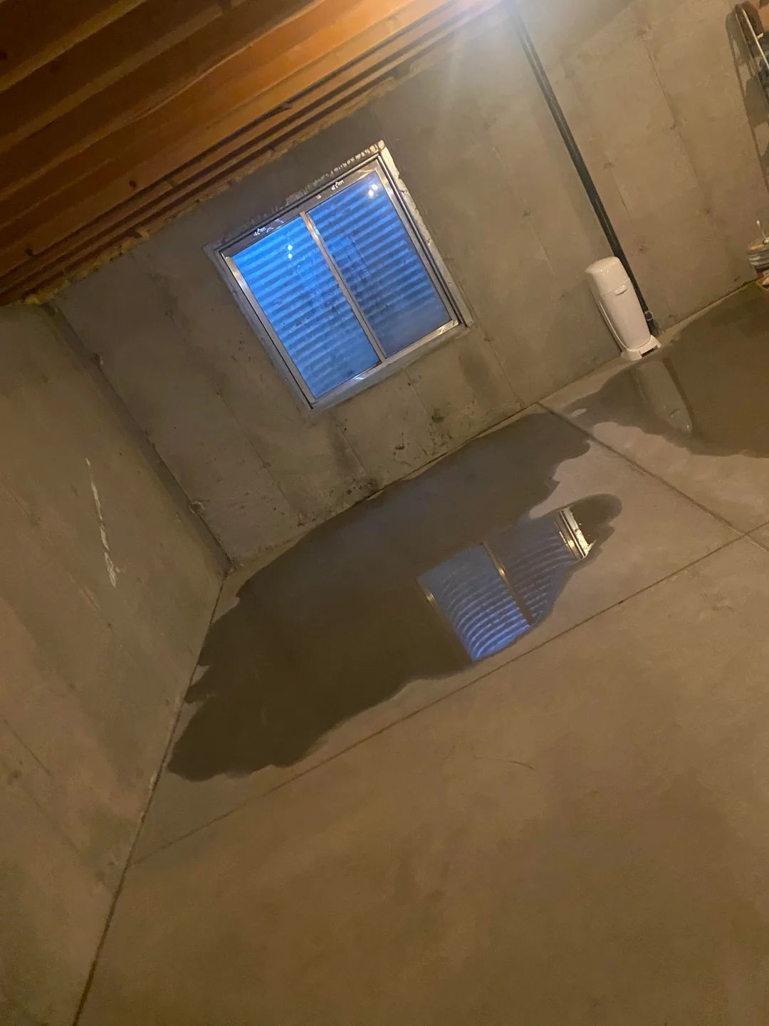 Downspout and exterior foundation wall of a Portland home before exterior basement waterproofing