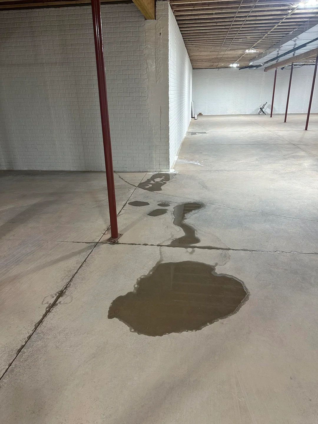Basement waterproofing Portland crew excavating to the footing for helical pier installation in Woodstock