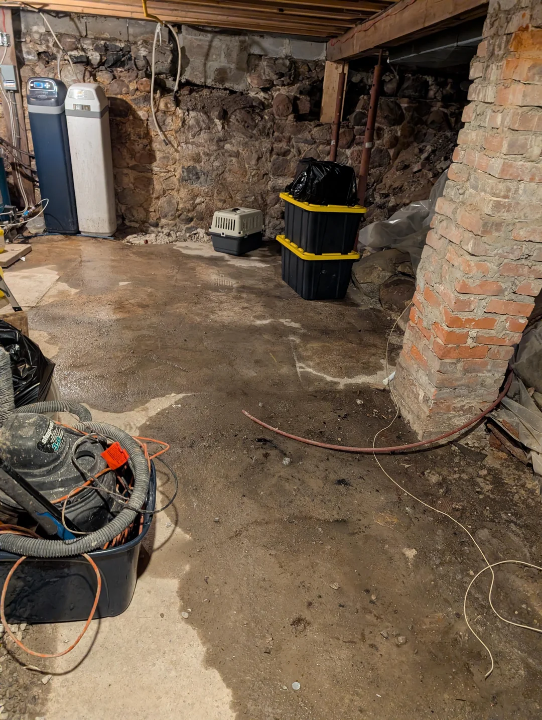 Standing water on an older Portland basement floor before choosing an interior or exterior basement waterproofing method
