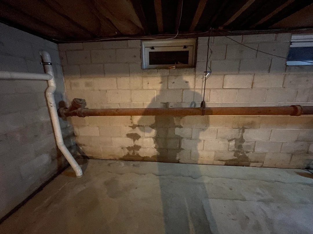 Basement wall corner with a floor drain, part of a Portland basement waterproofing drainage system